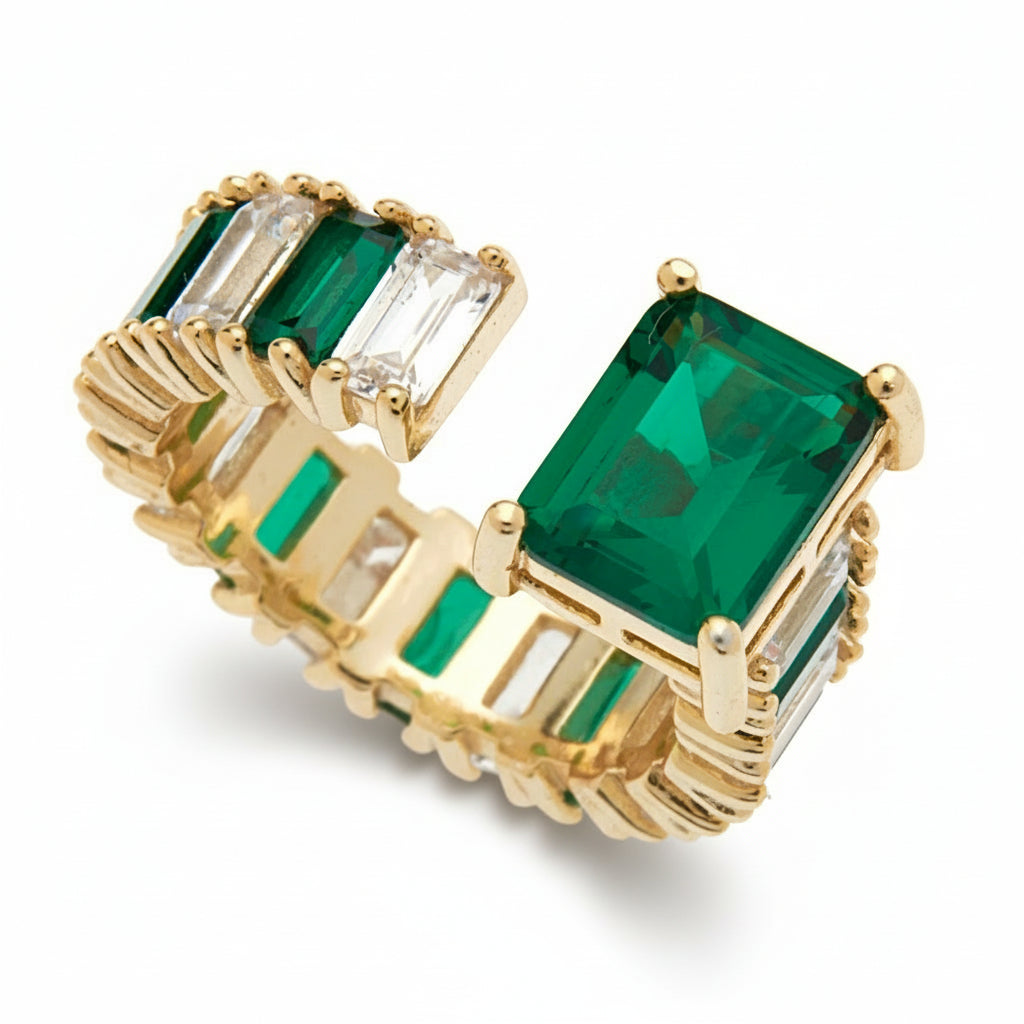 Gold ring with rectangular green and clear cubic zirconia stones on a white background