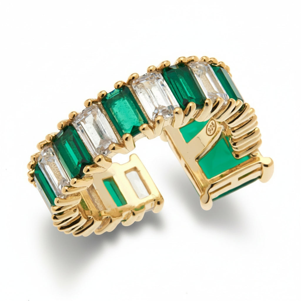 Gold ring with rectangular green and clear cubic zirconia stones on a white background