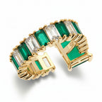 Gold ring with rectangular green and clear cubic zirconia stones on a white background