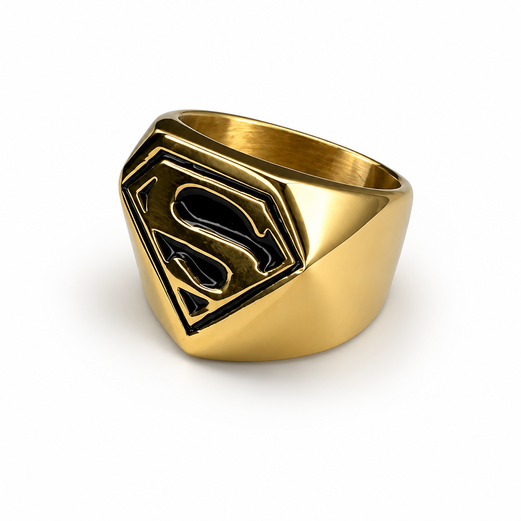 A gold stainless steel signet ring featuring a raised Superman 'S' shield emblem with black enamel detailing, shown on a clean white background.