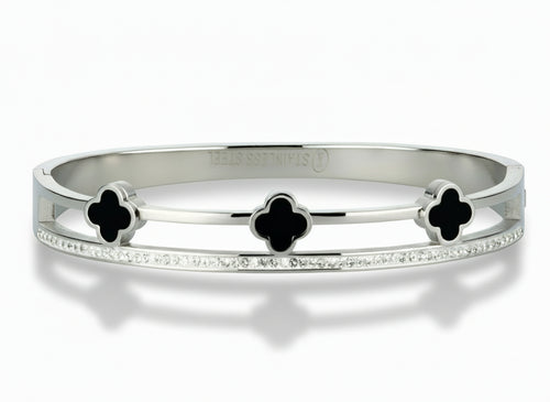 Silver bangle with black onyx clover-shaped stones on a white background