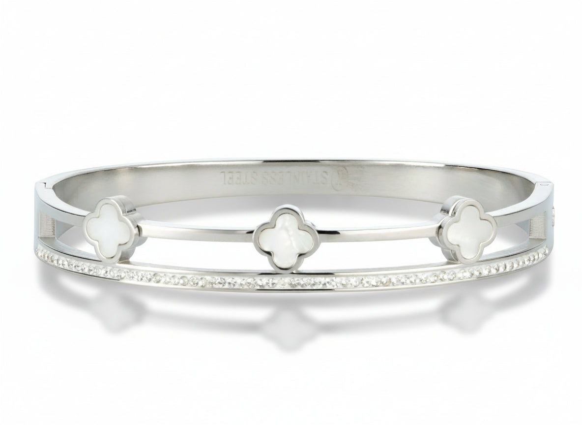Silver bandle bracelet with mother of pearl clover-shaped charms and cubic zirconis on a white background