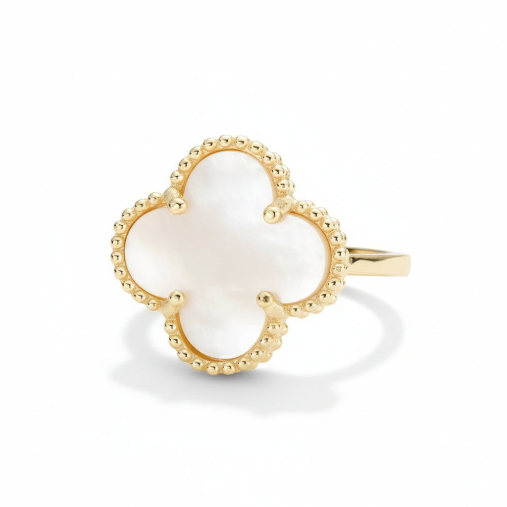 Gold-toned ring with a pearlescent mother of pearl clover-shaped stone on a white background