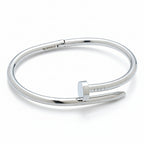 Stainless steel bangle with a nail design on a white background