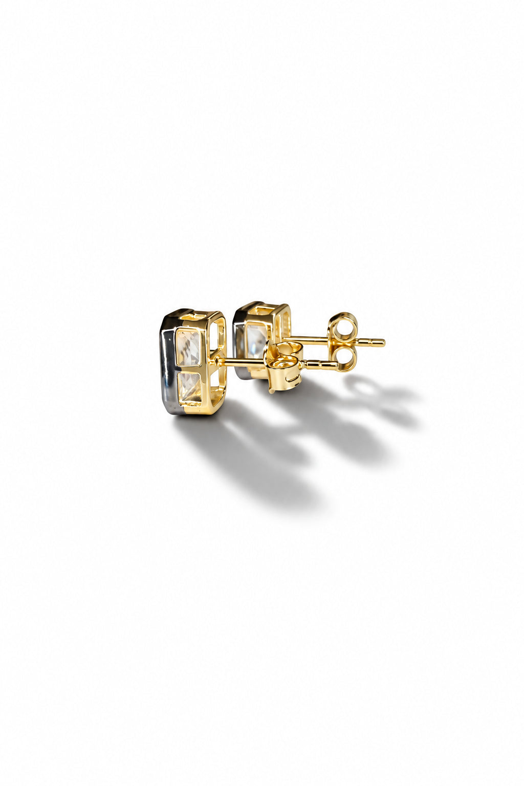 Side view of CZ stud earrings with black enamel bezels, sterling silver with 14K gold and rhodium plating, and post backs.