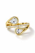 Gold-tone wrap ring with two pear-cut CZ stones in bezel settings and pavé CZ accents along the curved band.