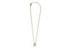 Gold necklace with a cubic zirconia pendant on a white background